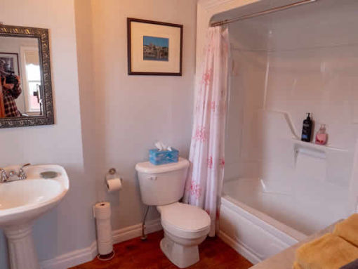 image: view of bathroom tub, toilet and sink